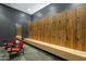 Well-lit locker room with modern wood lockers and red chairs at 7120 E Kierland Blvd # 311, Scottsdale, AZ 85254