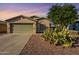 Single-story house with a two-car garage and desert landscaping at 7334 S Morning Dew Ln, Buckeye, AZ 85326