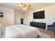 Main bedroom with large TV and gray accent chair at 7334 S Morning Dew Ln, Buckeye, AZ 85326