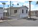 Well-maintained mobile home with a covered carport and desert landscaping under a sunny sky at 7807 E Main St # F36, Mesa, AZ 85207