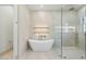 Bright bathroom showcases a modern soaking tub, glass shower, and floating wood shelves at 8169 E Redberry --, Mesa, AZ 85207