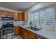 Kitchen with stainless steel sink, wood cabinets, and window at 8732 W Rockwood Dr, Peoria, AZ 85382