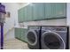 Laundry room with green cabinets, washer, dryer, and utility sink at 922 E Desert Hills Estate Dr, Phoenix, AZ 85086