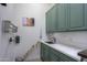 Bright laundry room with green cabinets, built-in drying rack, and ample storage at 922 E Desert Hills Estate Dr, Phoenix, AZ 85086