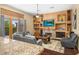 Open-concept Gathering room with a stone fireplace, built-in shelving, and hardwood floors at 9255 W Buckskin Trl, Peoria, AZ 85383