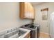 Laundry room with washer, dryer, cabinets, and utility sink at 9255 W Buckskin Trl, Peoria, AZ 85383