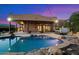 Blue pool and hot tub with rocks and string lights at sunset at 9255 W Buckskin Trl, Peoria, AZ 85383