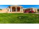 Beautiful tan home with columns, lush lawn, and manicured landscaping at 928 E Valencia Dr, Phoenix, AZ 85042