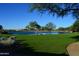 Serene community lake with lush green landscaping and seating area at 10040 E Happy Valley Rd # 1041, Scottsdale, AZ 85255