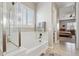 Elegant bathroom with a soaking tub, walk-in shower, and views of the backyard at 10062 W Redbird Rd, Peoria, AZ 85383