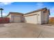 Three-car garage with light beige doors and a large concrete driveway at 1040 N 113Th Pl, Mesa, AZ 85207