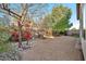 Landscaped backyard with gravel, mature trees, and colorful flowers at 10634 W Mohawk Ln, Peoria, AZ 85382