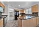 Open kitchen with island, granite countertops, and a view into the adjacent living area at 10634 W Mohawk Ln, Peoria, AZ 85382