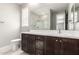 Modern bathroom with dark brown vanity and a large mirror at 11667 W Marguerite Ave, Avondale, AZ 85323