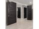 Bright hallway with dark doors leading to bedrooms and closets at 11667 W Marguerite Ave, Avondale, AZ 85323