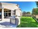 Outdoor kitchen and grassy backyard at 12079 E Cortez Dr, Scottsdale, AZ 85259