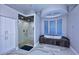 Bathroom with a large soaking tub, glass shower, and marble flooring at 12079 E Cortez Dr, Scottsdale, AZ 85259