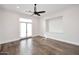 Large bedroom with hardwood floors, ceiling fan, balcony access, and built-in shelves at 12079 E Cortez Dr, Scottsdale, AZ 85259