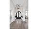 Grand foyer features arched doorways, wood floors, and a modern chandelier over the black double doors at 12079 E Cortez Dr, Scottsdale, AZ 85259