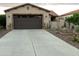 Two-car garage with dark brown doors and a long concrete driveway at 12979 W Roy Rogers Rd, Peoria, AZ 85383