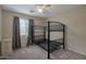 Neutral bedroom features a black bunk bed, a ceiling fan and window with drapes at 15144 W Washington St, Goodyear, AZ 85338