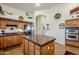 Modern kitchen with island, stainless steel appliances, and wood cabinets at 16364 W Roosevelt St, Goodyear, AZ 85338