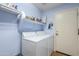 Laundry room with washer, dryer, and shelving at 16364 W Roosevelt St, Goodyear, AZ 85338