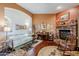 Cozy living room with a brick fireplace and hardwood floors at 16364 W Roosevelt St, Goodyear, AZ 85338