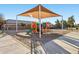 A covered playground features colorful equipment and a slide, perfect for outdoor fun in a Gathering-friendly community at 19339 N Madison Rd, Maricopa, AZ 85139