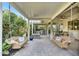 Extensive covered patio with hanging sofas, dining area, and built-in outdoor kitchen, perfect for entertaining at 210 E Bergamot Ln, Queen Creek, AZ 85140