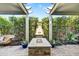 Charming backyard fire pit with pergola and a beautiful water fountain and lush landscaping at 210 E Bergamot Ln, Queen Creek, AZ 85140