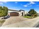Inviting single-story home featuring a brick driveway, two-car garage, and manicured landscaping at 210 E Bergamot Ln, Queen Creek, AZ 85140