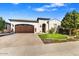 Charming single-story home with a well-manicured lawn, brick driveway, and a two-car garage at 210 E Bergamot Ln, Queen Creek, AZ 85140