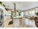 Open-concept kitchen featuring stainless steel appliances, a center island, and seamless access to an adjacent sitting area at 210 E Bergamot Ln, Queen Creek, AZ 85140