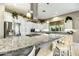 Bright kitchen showcases granite counters, sleek stainless appliances, overhead lighting, and eat-in island with stool seating at 210 E Bergamot Ln, Queen Creek, AZ 85140