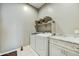 Functional laundry room with front-load washer/dryer, counter space, and decorative shelving for organized convenience at 210 E Bergamot Ln, Queen Creek, AZ 85140