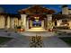Elegant outdoor gathering area with stone pillars, a fireplace, and landscape lighting at 210 E Bergamot Ln, Queen Creek, AZ 85140