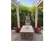 Beautiful patio showcasing a stone water feature, pergola, and vibrant floral accents at 210 E Bergamot Ln, Queen Creek, AZ 85140
