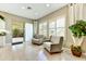 Comfortable sitting area with two rocking chairs, plantation shutters, and sliding glass door to an outdoor patio at 210 E Bergamot Ln, Queen Creek, AZ 85140