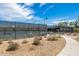 Well-lit tennis courts with perimeter fencing and a nearby bench at 2156 W Sierra Sunset Trl, Phoenix, AZ 85085