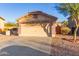 Front view of a house with a two-car garage and walkway at 22270 W Desert Bloom St, Buckeye, AZ 85326