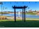 Serene lake view with a pergola and fountain at 24623 S Lakeway Se Cir, Sun Lakes, AZ 85248