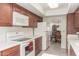 View of kitchen with white appliances and wood cabinets at 25244 S Saddletree Dr, Sun Lakes, AZ 85248
