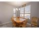 Well-lit dining room with wood table and chairs, and window with blinds at 2734 E Birchwood Pl, Chandler, AZ 85249