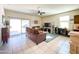 Living room features sliding glass doors, plush sofas, and a large TV at 3841 N 293Rd Dr, Buckeye, AZ 85396