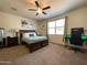 Main bedroom with carpeted floor, ceiling fan, and built-in desk at 3841 N 293Rd Dr, Buckeye, AZ 85396