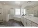 Bright bathroom featuring dual sinks, large mirrors, white cabinets, and a separate shower and tub at 4747 S Aileron Ln, Mesa, AZ 85212