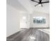 Living room with grey vinyl flooring, white walls, and a window at 6022 W Mauna Loa Ln, Glendale, AZ 85306