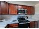 Modern kitchen with stainless steel appliances and wood cabinets at 750 E Northern Ave # 1053, Phoenix, AZ 85020