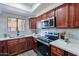 Modern kitchen with stainless steel appliances and rich wood cabinets at 750 E Northern Ave # 1053, Phoenix, AZ 85020